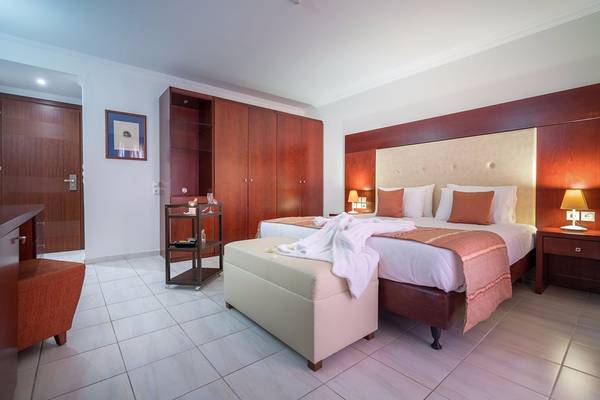 Ein elegantes Hotelzimmer im Galaxy Beach Resort mit einem großen Bett, Holzmöbeln und einem modernen Dekor.