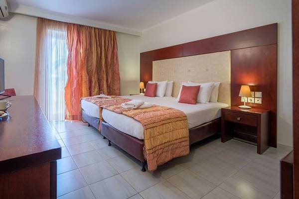 Doppelbettzimmer im Galaxy Beach Resort Hotel mit Fernseher, Nachttischen und Bettwäsche.