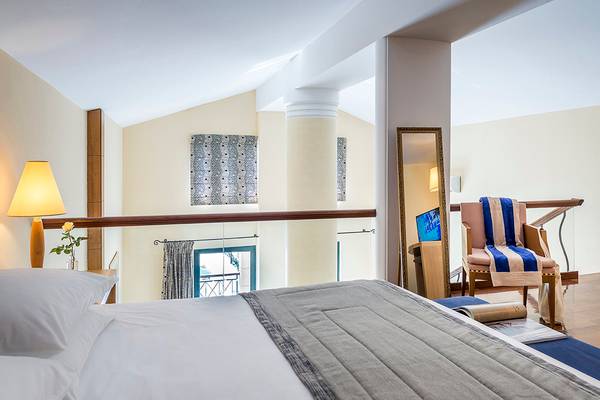 Schlafzimmer im Mitsis Lindos Memories Resort & Spa mit Bett, Fenster und Balkon