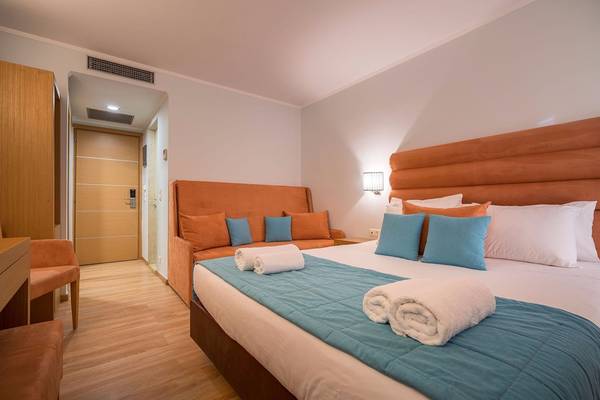 Schlafzimmer im Galaxy Beach Resort mit Bett, Kissen, Couch und Nachttisch