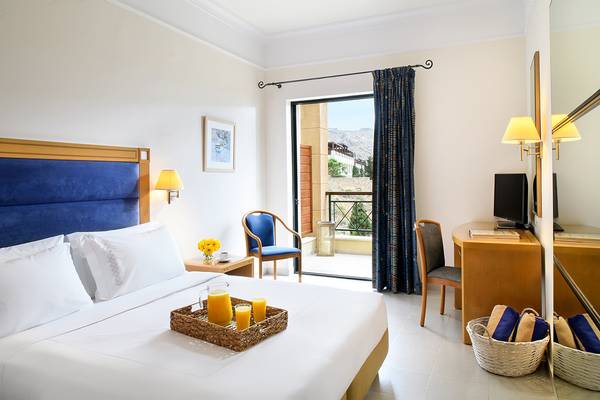 Zimmer im Mitsis Lindos Memories Resort & Spa mit einem Bett, einem Balkon und einem Schreibtisch.