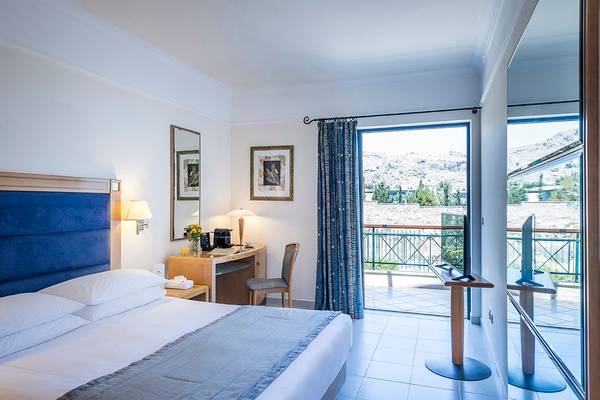 Hotelzimmer im Mitsis Lindos Memories Resort & Spa mit Balkon, Fernseher und Schreibtisch.