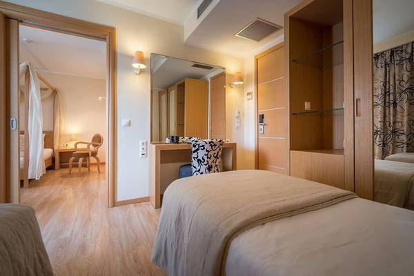 Innenansicht eines Hotelzimmers im Galaxy Beach Resort mit zwei Betten, Schreibtisch und Spiegel.