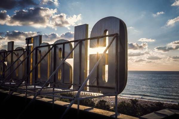 Schild des Gladiola Star Hotels am Meer bei Sonnenuntergang.