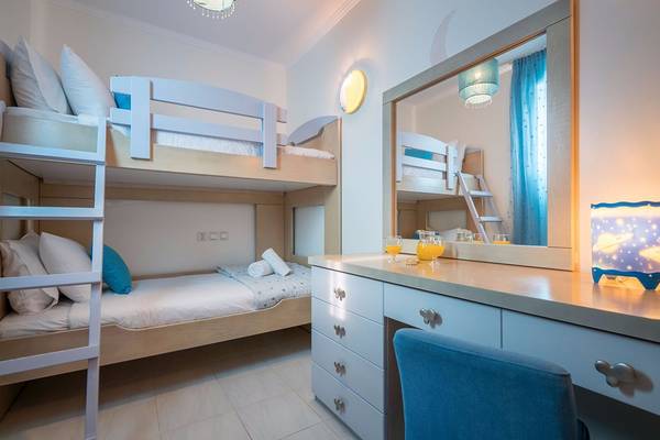 Schlafzimmer im Galaxy Beach Resort mit zwei Stockbetten, Nachttisch und Spiegel.