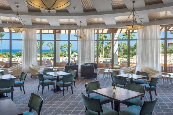 Innenansicht des Elysium Hotel Restaurants mit großen Fenstern und Meerblick.