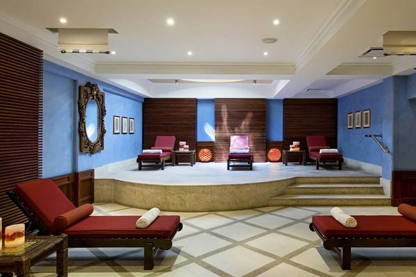Spa-Lounge im Elysium Hotel mit roten Liegen und blauen Wänden.