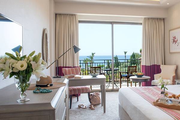 Elysium Hotel Suite Zimmer mit Meerblick, Bett, Balkon, Frühstückstablett, und Meersicht.
