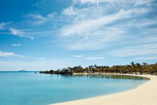 Strand des LUX Grand Gaube Resort & Villas mit blauem Meer und weißen Palmen.