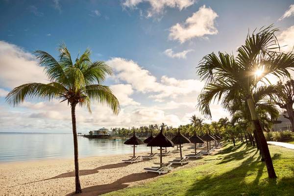 Strand des LUX Grand Gaube Resort & Villas mit Palmen und Sonnenschirmen