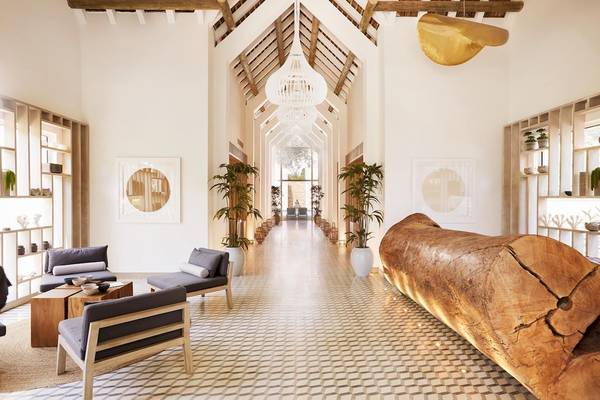 Lobby des LUX Grand Gaube Resort & Villas mit langen Flur, Holzmöbeln und Pflanzen