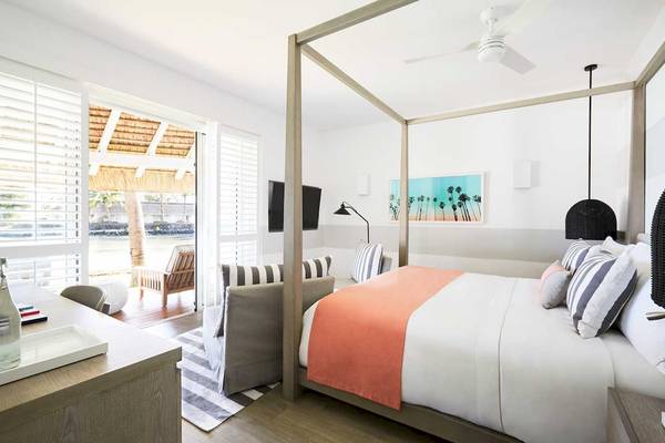 Schlafzimmer im LUX Grand Gaube Resort & Villas mit Himmelbett, Wohnzimmerbereich und Meerblick.