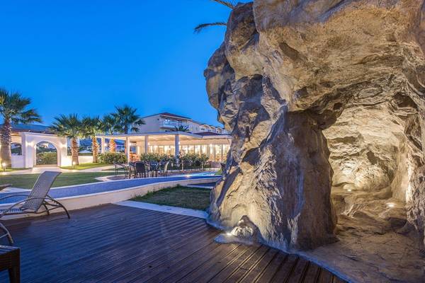 Außenbereich des Galaxy Beach Resorts bei Nacht mit Pool und Liegestühlen.