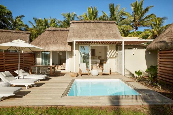 Außenbereich des LUX Grand Gaube Resort & Villas mit Swimmingpool, Loungestühlen und Sonnenschirm.