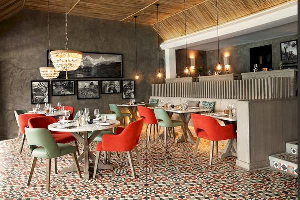 Innenansicht des Restaurants im LUX Grand Gaube Resort & Villas mit bunten Stühlen und Tischen.