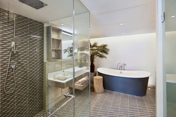 Badezimmer im LUX Grand Gaube Resort & Villas mit blauer Badewanne und Regendusche.