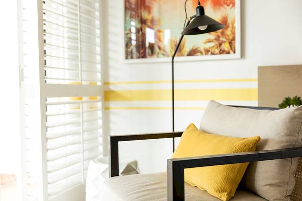 Wohnzimmer des LUX Grand Gaube Resort & Villas mit einem Sofa, Kissen und einer Stehlampe.