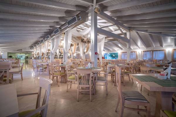 Innenansicht des Restaurants des Galaxy Beach Resorts mit runden Tischen und Stühlen.