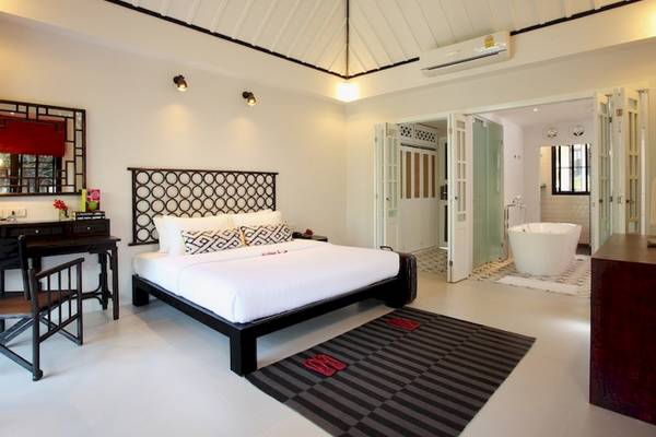 Moracea by Khao Lak Resort Schlafzimmer mit Bett, Badewanne und Schreibtisch.