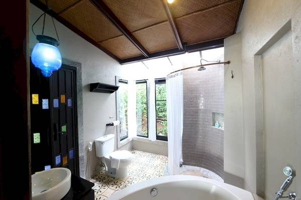 Badezimmer im Moracea by Khao Lak Resort mit Badewanne, Dusche und Toilette.