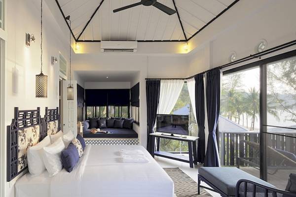 Schlafzimmer im Moracea by Khao Lak Resort mit großem Bett, Tageslicht, Fernseher und Balkon.