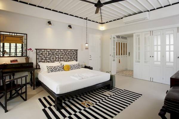 Hotelzimmer im Moracea by Khao Lak Resort mit großem Bett, schwarzen und weißen Möbeln und einer Decke mit Ventilator