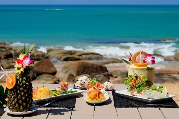 Essen auf einem Tisch am Strand im Moracea by Khao Lak Resort.