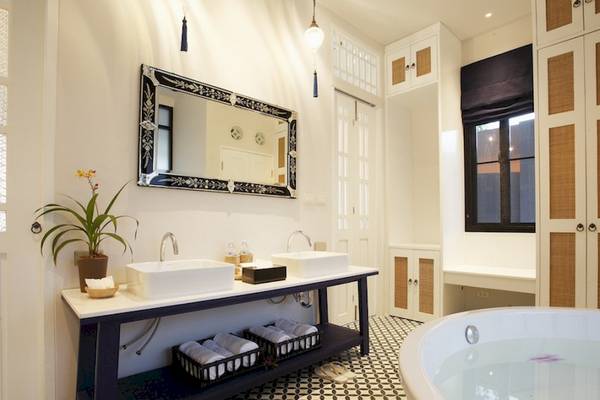 Badezimmer im Moracea by Khao Lak Resort mit zwei Waschbecken, einem großen Spiegel und einer Badewanne.