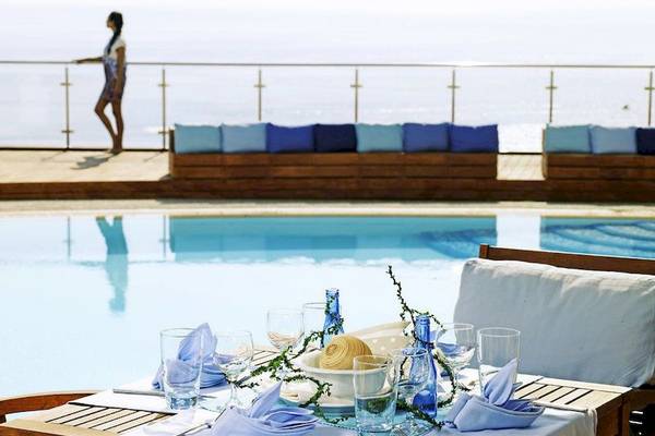 Tisch mit blauen Kissen und Gläsern neben dem Pool im Esperos Village Blue & Spa.