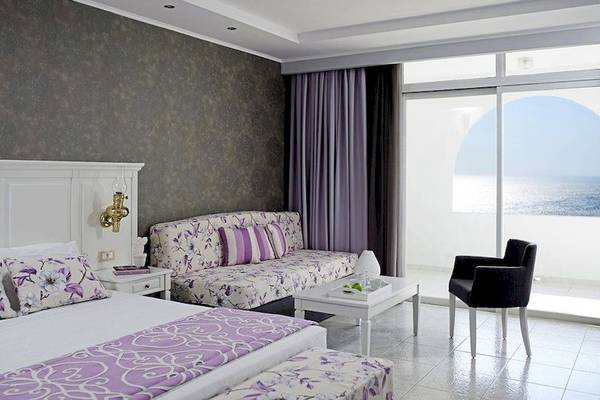 Doppelzimmer mit Meerblick im Esperos Village Blue & Spa mit luxuriösem Interieur, Kingsize-Bett, Wohnzimmerbereich und Balkon mit Meersicht.