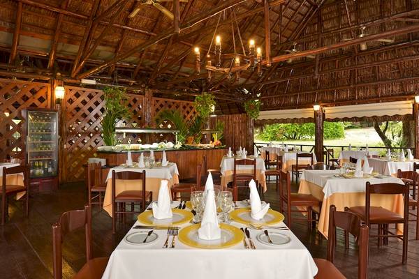 Innenansicht des Restaurants im Iberostar Tainos Hotel mit Holzmöbeln und Deckenventilatoren.