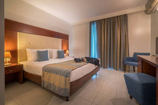 Innenansicht eines Hotelzimmers im Galaxy Beach Resort mit Bett, Nachttischen und Klimaanlage.