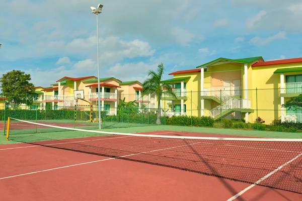 Tennisplatz im Iberostar Tainos Hotel mit gelben Gebäuden und blauem Himmel