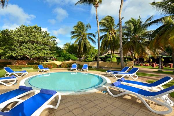 Pool-Lounge-Bereich im Iberostar Tainos Hotel mit blauen Liegen und Palmen.