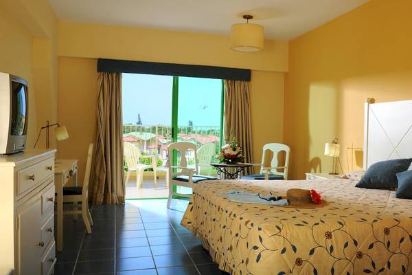 Hotelzimmer des Iberostar Tainos mit Balkon, Bett, Schreibtisch und Fernseher.