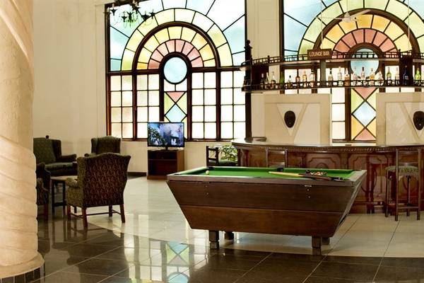 Pooltisch im Neptune Beach Resort Loungebereich mit bunten Glasfenstern im Hintergrund.