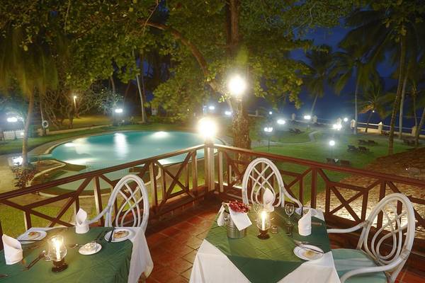 Nachtliche Terrasse des Neptune Beach Resort in Kenia mit Swimmingpool und illuminierten Wegen.