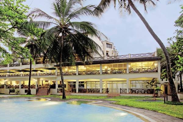 Außenansicht des Neptune Beach Resorts in Kenia mit Pool und Palmen