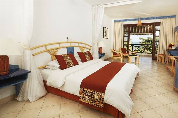 Hotelzimmer im Neptune Beach Resort in Kenia mit Blick auf den Ozean.