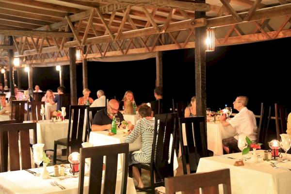 Abendessen im Freien im La Digue Island Lodge Restaurant mit Gästen an Tischen.