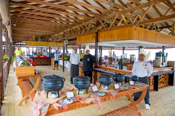 Innenansicht des Restaurants des La Digue Island Lodge mit Köchen, die Gerichte servieren