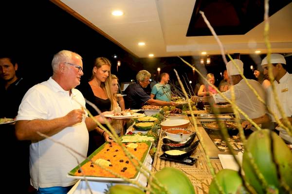 Mehrere Gäste bedienen sich an einem Buffet im La Digue Island Lodge.