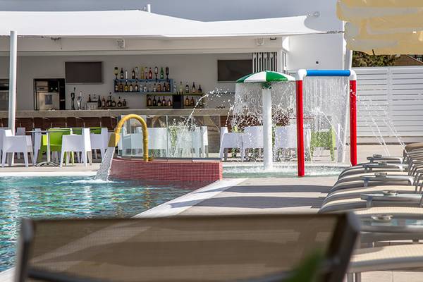 Außenbereich des Nicholas Color Hotels mit Pool, Bar und Liegestühlen.