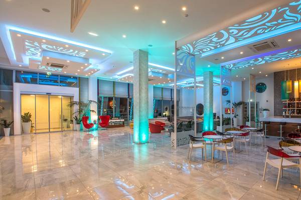 Lobby des Nicholas Color Hotels mit blauen und roten Lichtern und modernen Möbeln.