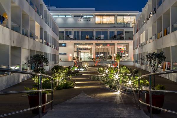 Der Eingangsbereich des Nicholas Color Hotels bei Nacht mit gut beleuchtetem Weg.