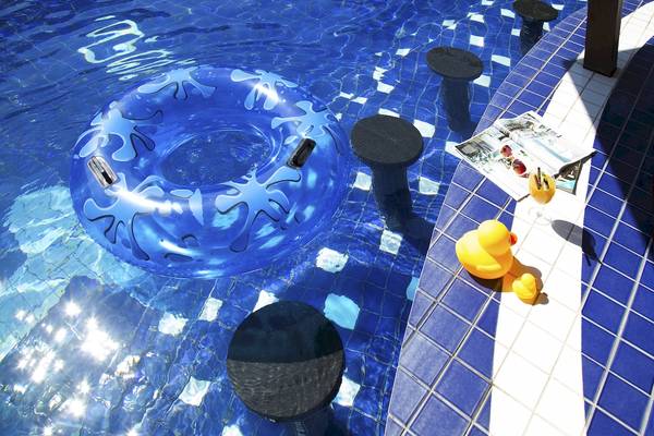 Schwimmbecken mit blauem Schwimmreifen und Entenfiguren am Rand