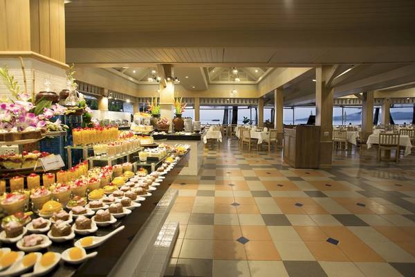Buffet im Best Western Premier Bangtao Beach Resort mit vielen Desserts und gedeckten Tischen.