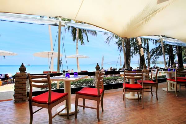Terrasse des Best Western Premier Bangtao Beach Resort mit Tischen und Stühlen und Blick auf den Strand