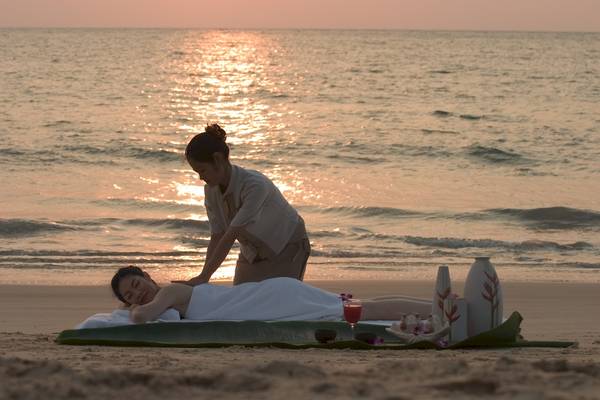 Spa-Massage am Strand des Best Western Premier Bangtao Beach Resort bei Sonnenuntergang.