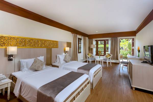 Zwei Betten in einem Zimmer des Best Western Premier Bangtao Beach Resort mit Möbeln und einem Fernseher.